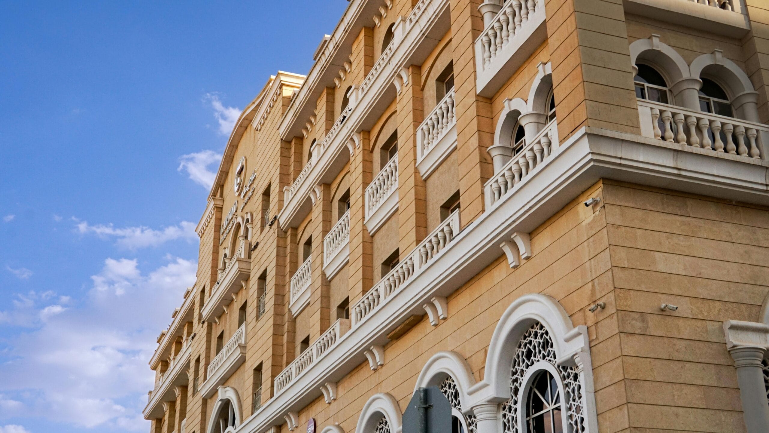 Capture of a classic architectural building facade in Saudi Arabia with clear blue skies.